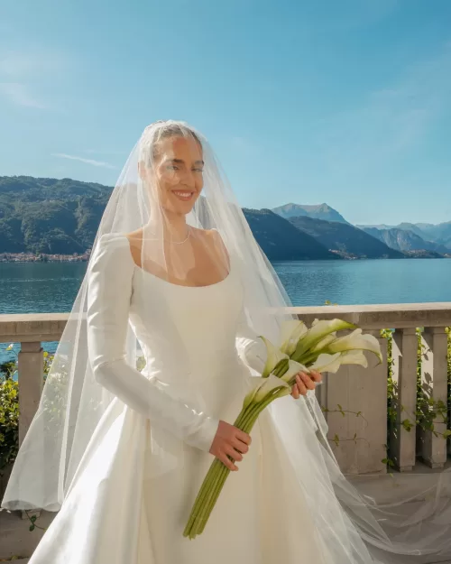 Bride smiling with calla lily bouquet overlooking Lake Como at Villa Lario Resort