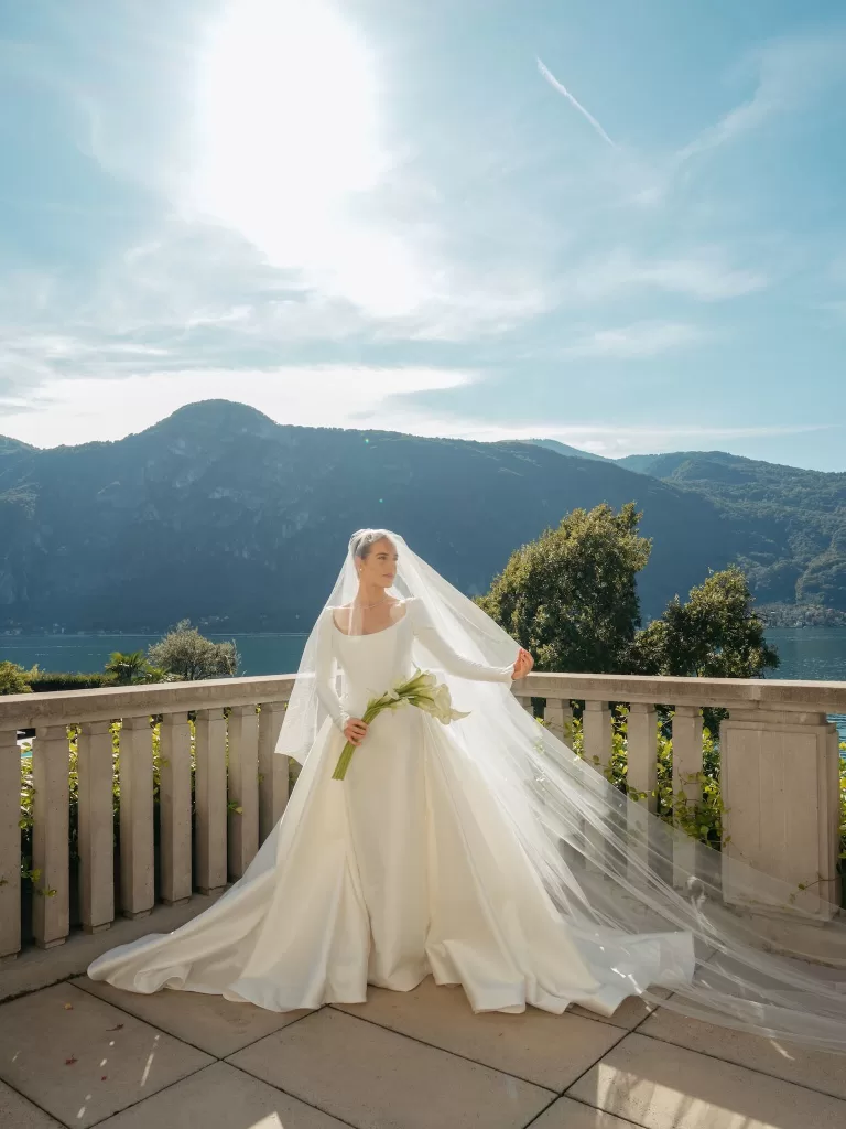 Bride holding calla lily bouquet with flowing veil on the terrace at Villa Lario Resort