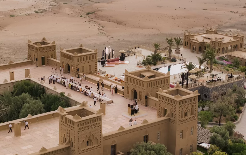 Overhead view of Amanjena’s central courtyard prepared for a wedding, framed by gardens, towers and desert landscape.