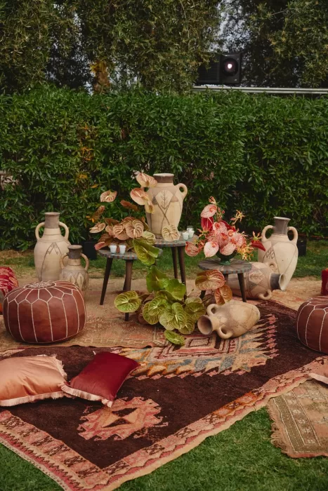 Wedding lounge styling at Amanjena featuring handwoven rugs, poufs, ceramic vases and sculptural floral arrangements.