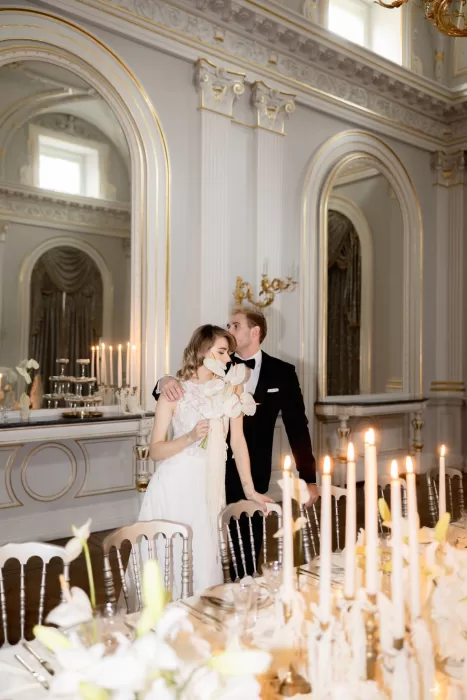 Bride and groom sharing a quiet moment at their candlelit reception table inside the grand interiors of Grand Hotel du Lac.