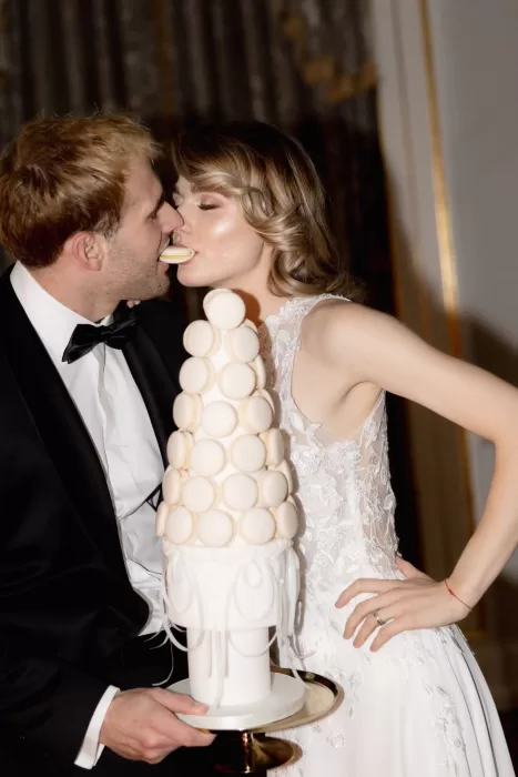 Bride and groom sharing a playful moment with their modern wedding cake during the reception at Grand Hotel du Lac.