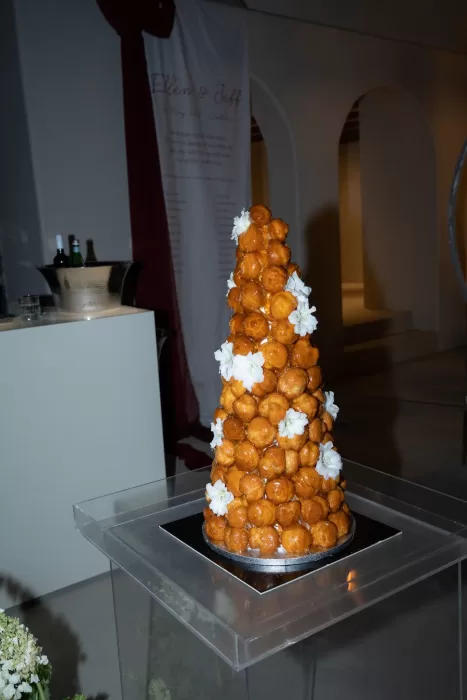 Croquembouche wedding cake displayed at an evening reception at Islet Santorini, styled with florals and contemporary decor.