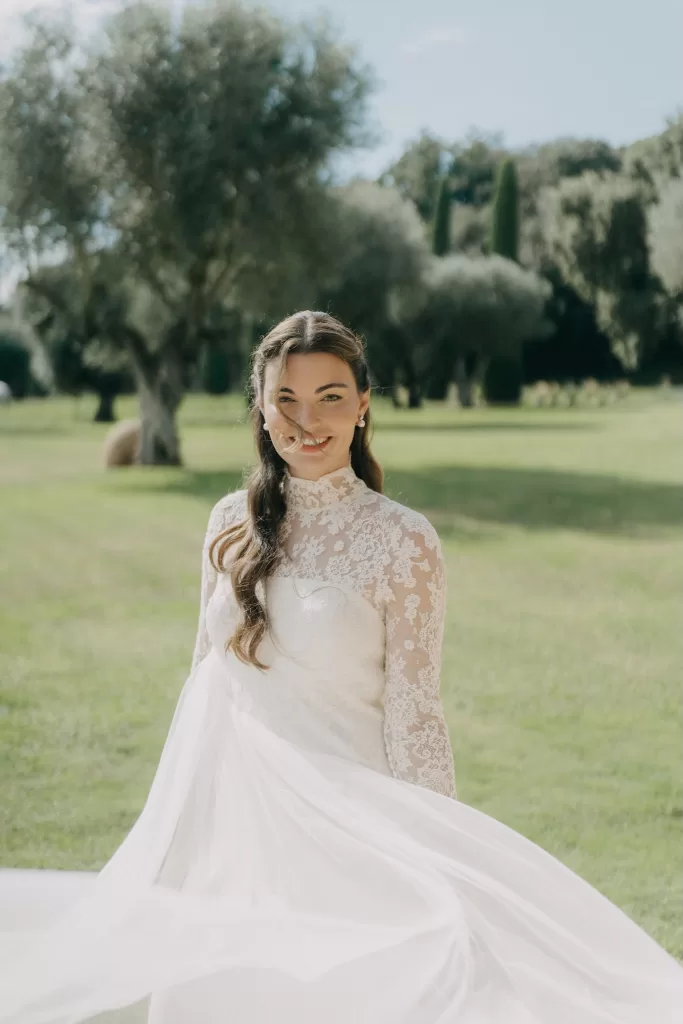 Natural bridal portrait in the gardens of Mas de Les Voltes, with flowing lace dress and olive trees in the background.