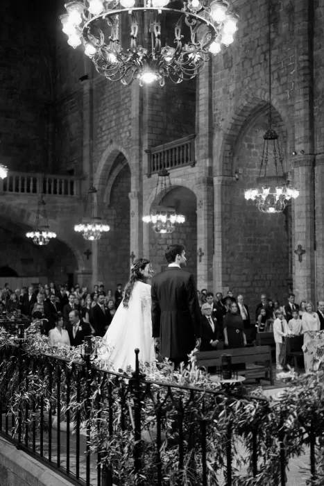 Bride and groom standing together during the ceremony inside the historic church near Mas de Les Voltes.