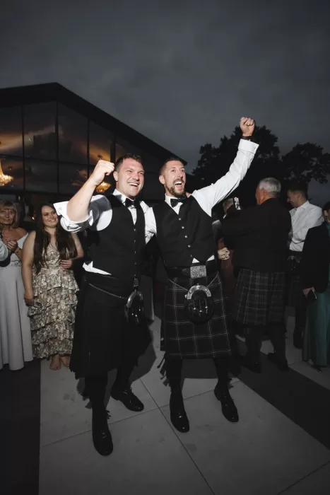 Wedding guests dancing during an energetic ceilidh celebration at Boturich Castle in Scotland.