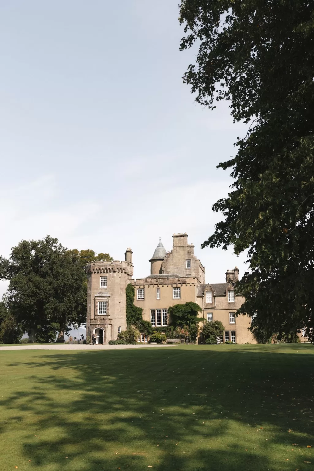 Boturich Castle exterior with manicured lawns and mature trees on a bright Scottish afternoon.
