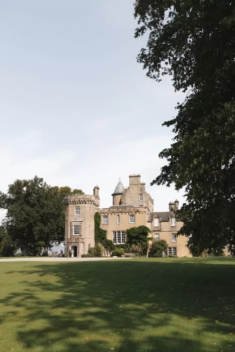 Boturich Castle exterior with manicured lawns and mature trees on a bright Scottish afternoon.