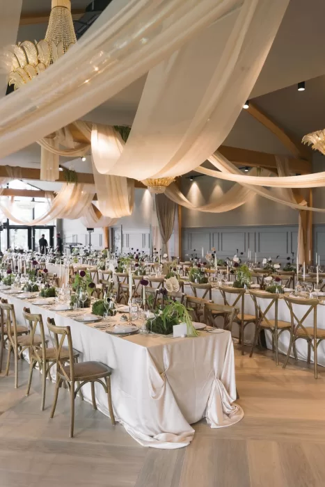Wedding reception room at Boturich Castle styled with long tables, draped ceilings and candlelight.