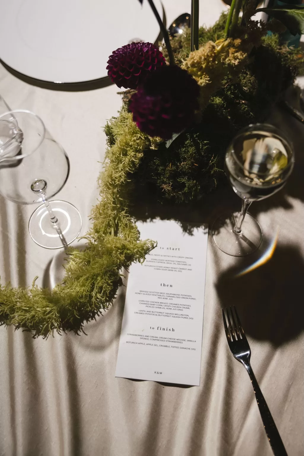 Wedding table styling with moss, florals and printed menus at Boturich Castle.