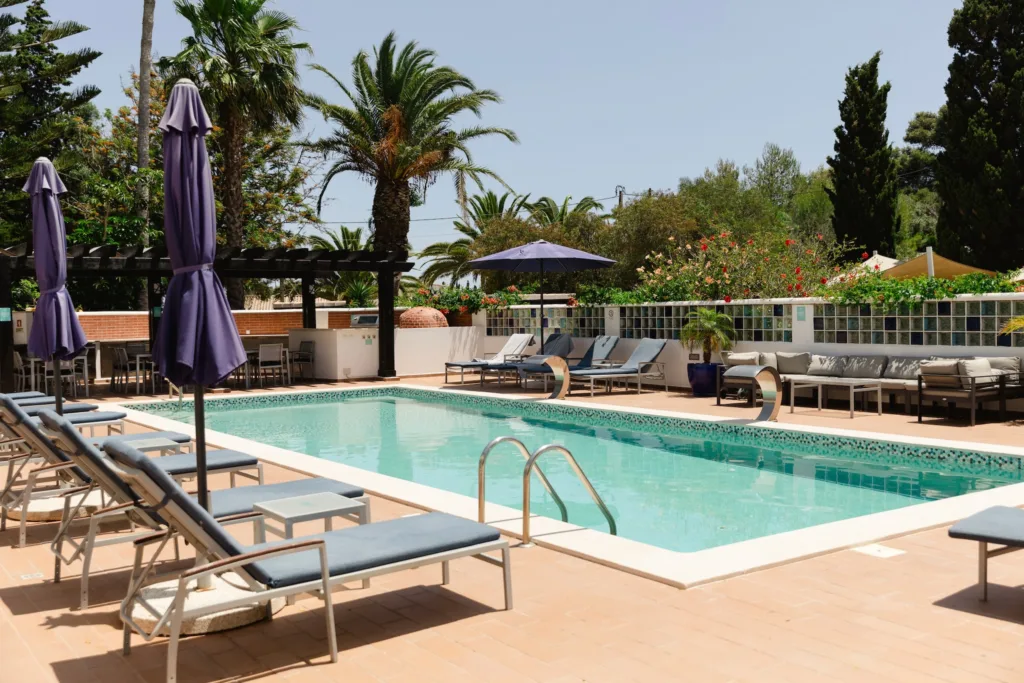 Sun loungers arranged beside the outdoor pool at Casa Monte Cristo Collection, set against terraced greenery.