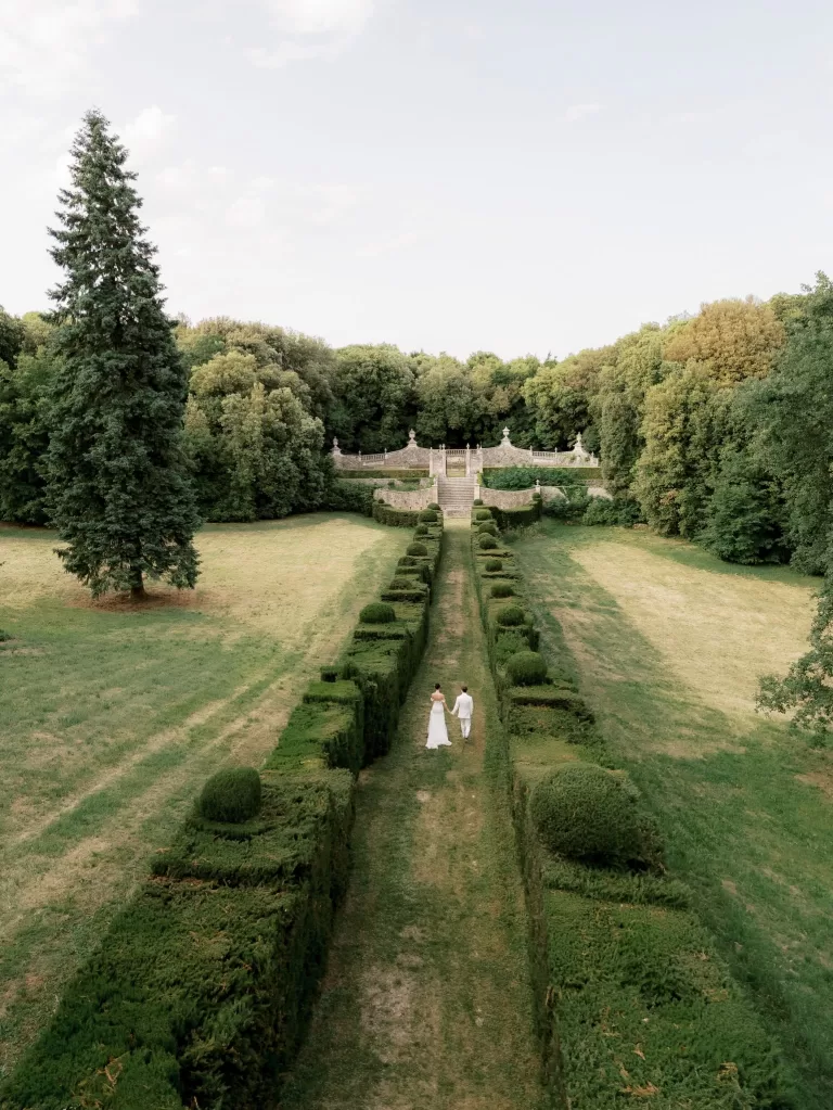 Aerial view of the manicured gardens at Castello di Celsa with symmetrical hedges and surrounding woodland.