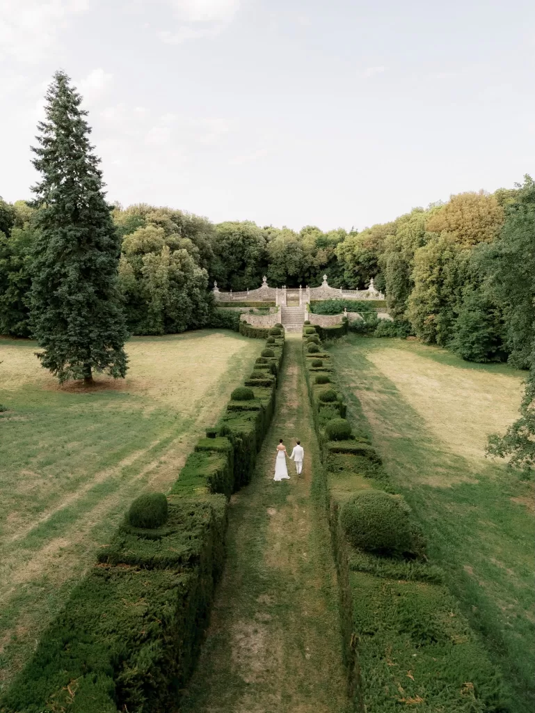 Aerial view of the manicured gardens at Castello di Celsa with symmetrical hedges and surrounding woodland.