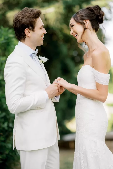 Bride and groom smiling as they hold hands during their outdoor ceremony at Castello di Celsa.