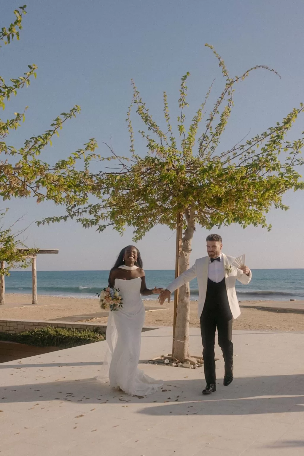 Newlyweds joyfully entering their beachside wedding venue at Coral Residences.