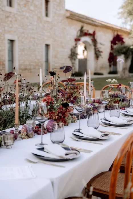 Refined place settings at Finca Morneta with gold cutlery, folded napkins and lush floral styling in front of the stone villa.