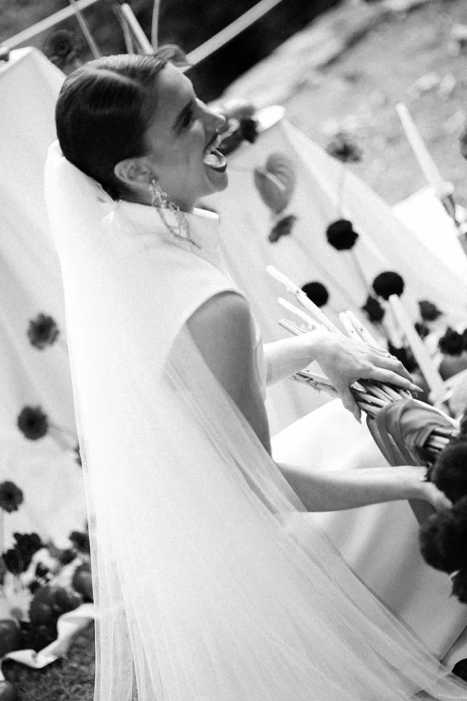 Close-up bridal portrait in white dress with statement gold earrings at Hotel Ristorante La Darsena surrounded by greenery.