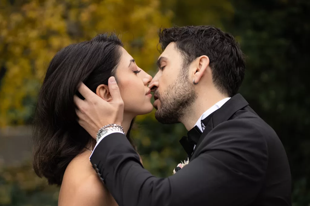 Close-up of bride and groom sharing an intimate kiss surrounded by autumn greenery at Villa Honegg.