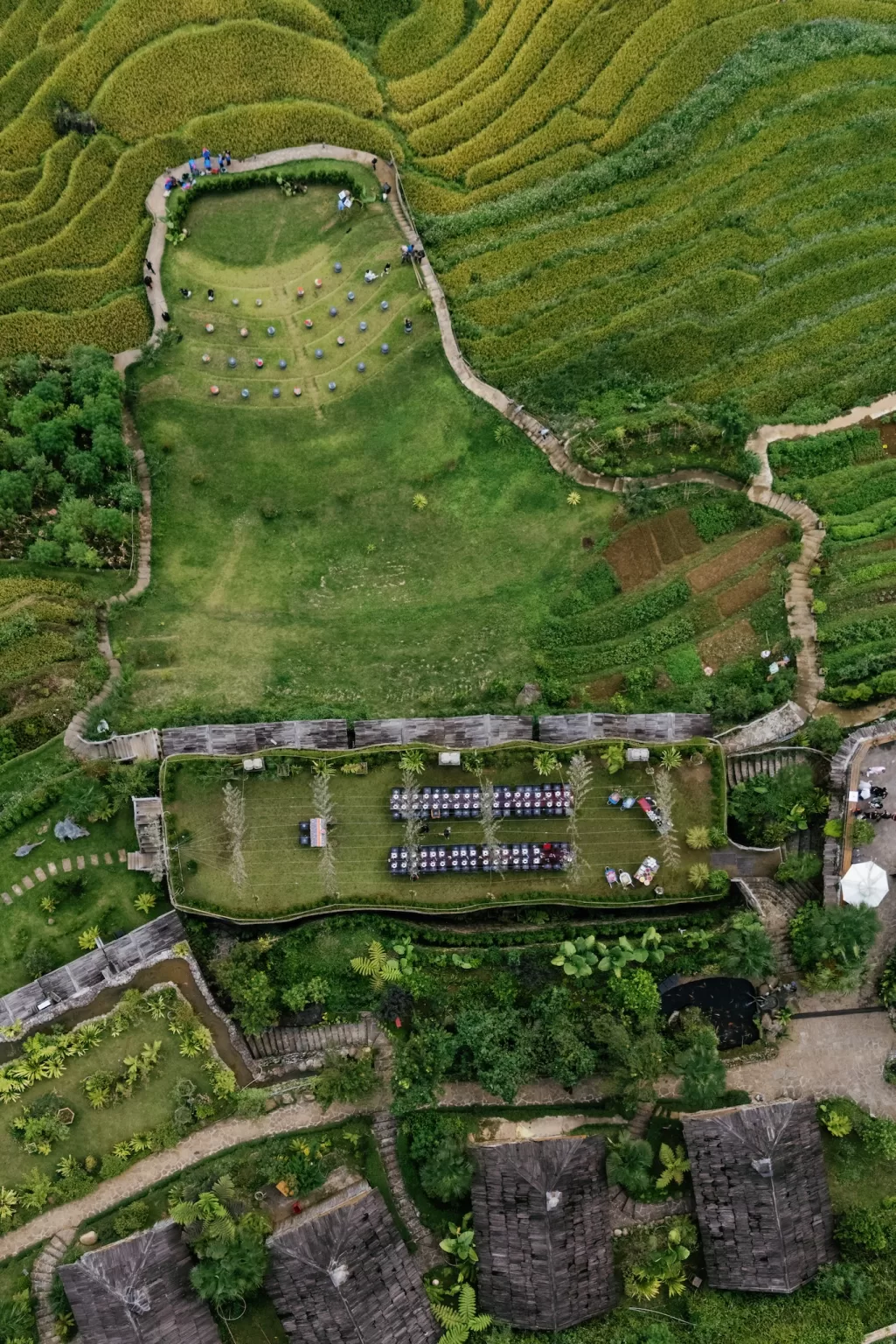 Aerial view of terraced rice fields and landscaped grounds surrounding Ville de Mont Mountain Resort.