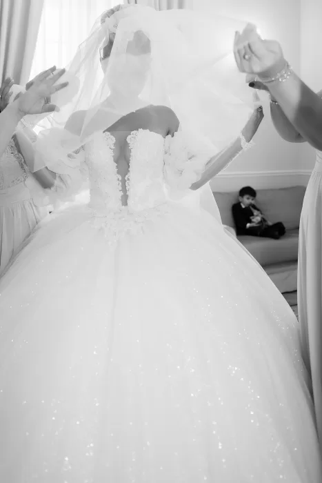 Bride having her veil adjusted during morning preparations at Château Bouffémont, captured in a timeless black and white moment.