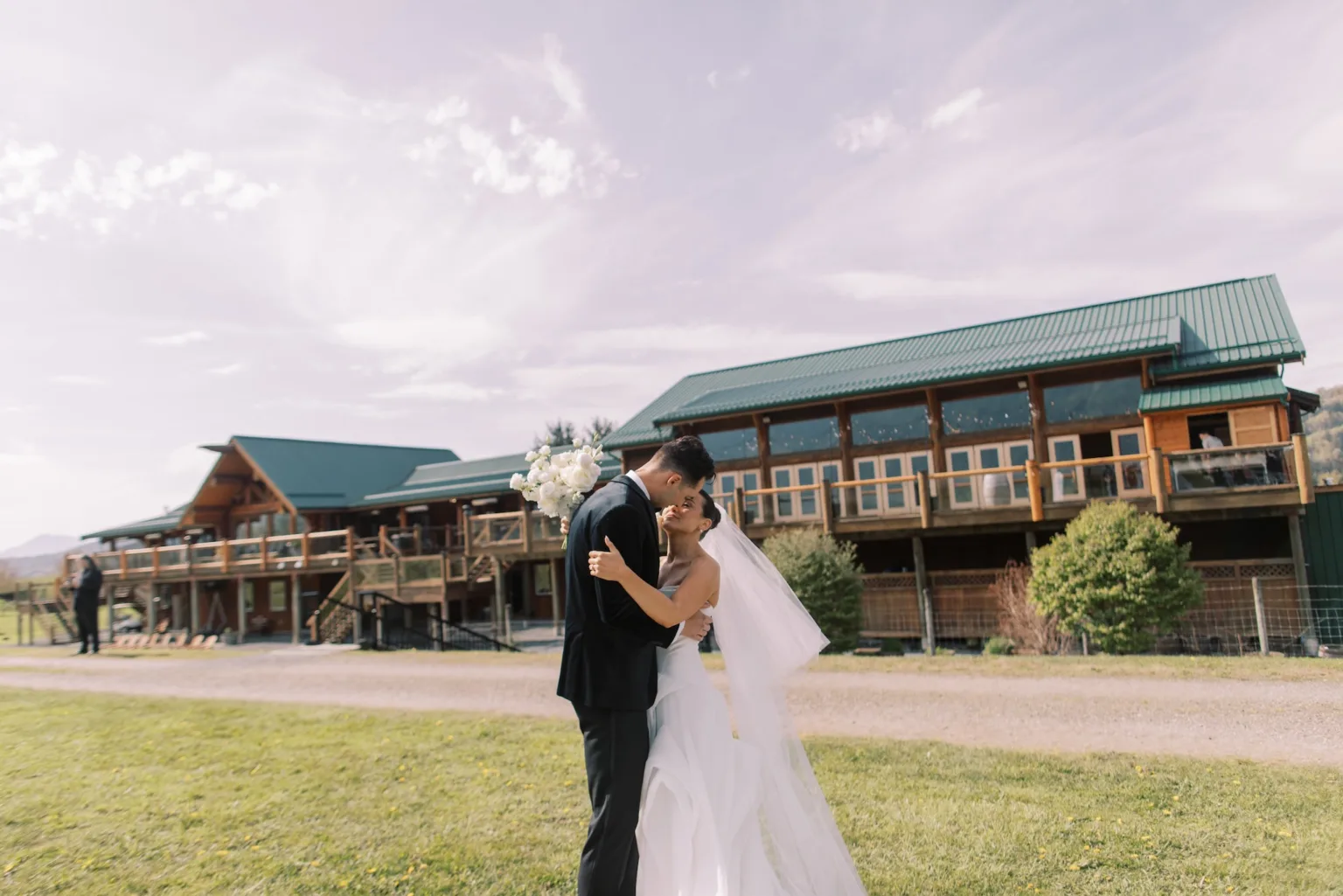 Fraser River Lodge exterior with ceremony setup and mountain backdrop in distance