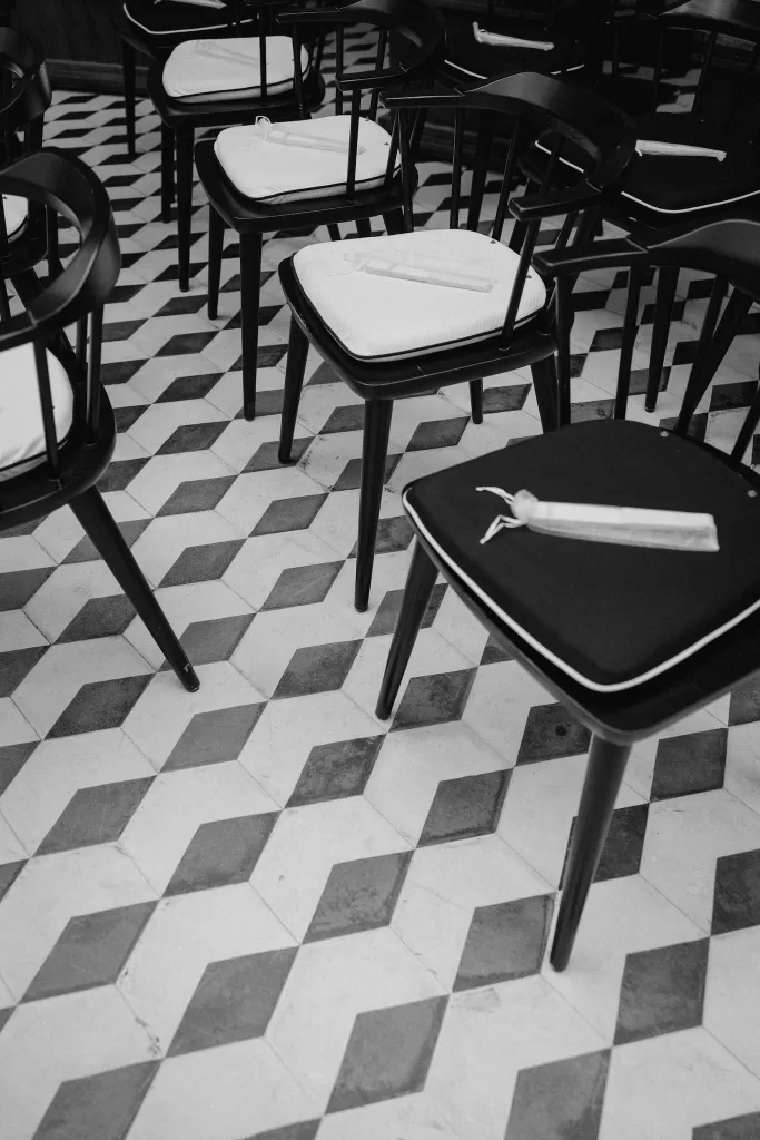 Minimalist black ceremony chairs arranged on patterned tile flooring in the Infante Sagres courtyard.