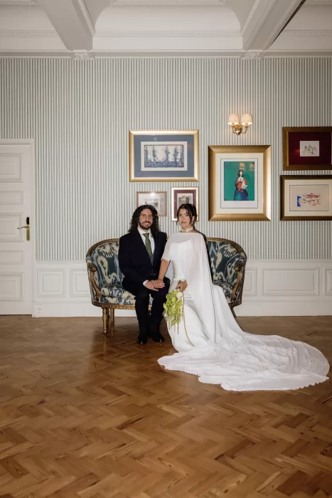 Bride and groom seated together for a portrait in an elegant salon at Infante Sagres.