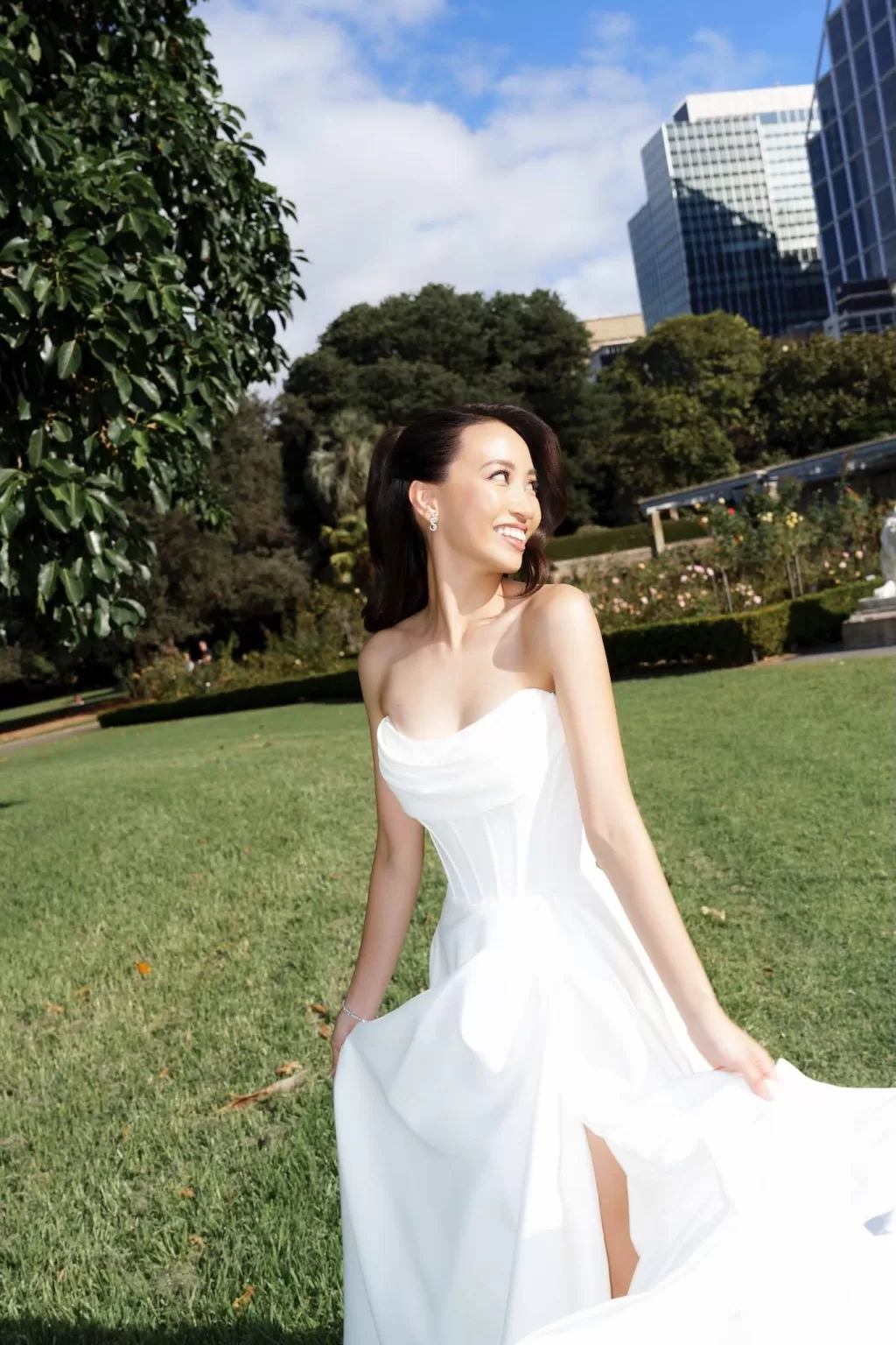 Bride in strapless white gown smiling in the garden at Next Chapter Events.