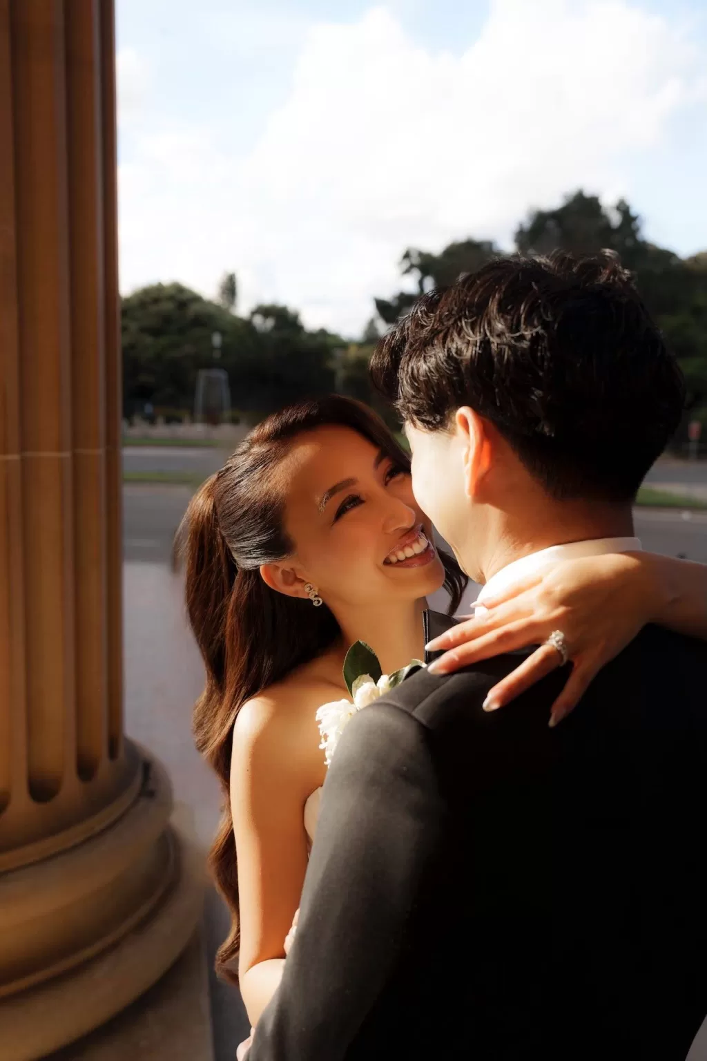 Bride smiling lovingly at the groom in the golden light outside Next Chapter Events.