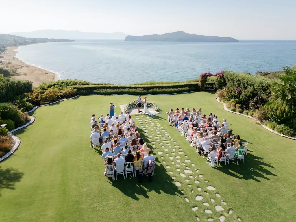 Aerial view of ceremony at Sea View by En Kipo with guests seated facing the ocean and stone pathway aisle