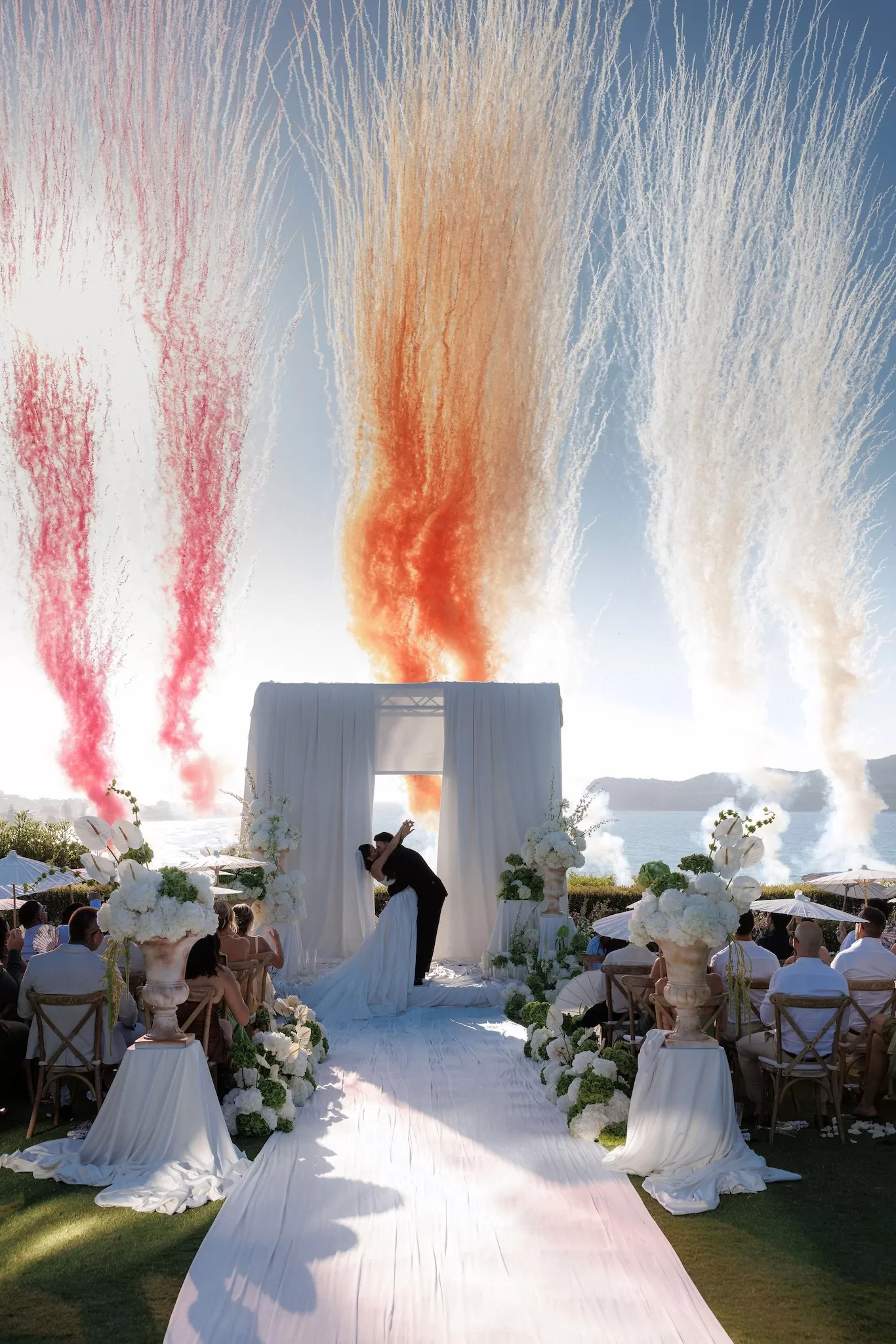 Floral-lined ceremony aisle at Sea View by En Kipo with white blooms and greenery overlooking the sea
