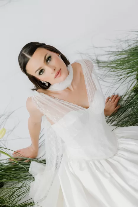 Overhead bridal portrait with lace bodice and flowing sleeves surrounded by soft greenery at Studio Sunset Chicago