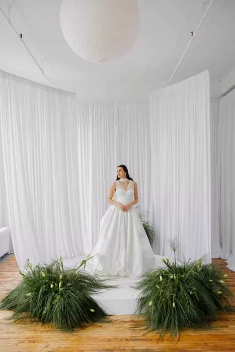 Wide ceremony setup with bride standing on circular platform surrounded by draped curtains and organic greenery at Studio Sunset Chicago