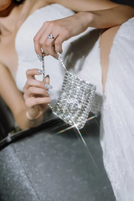 Close-up of crystal handbag catching light with lens flare against bridal gown at Studio Sunset Chicago