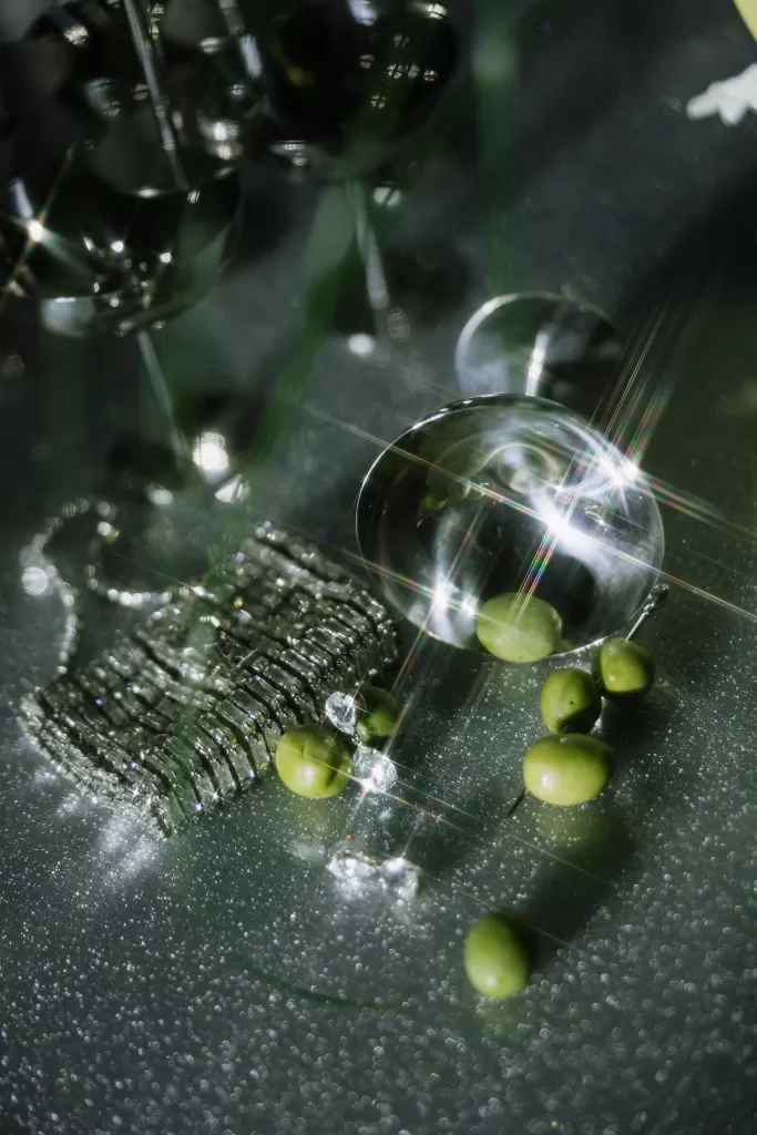 Sparkling glassware with olives and crystal textures catching light at Studio Sunset Chicago