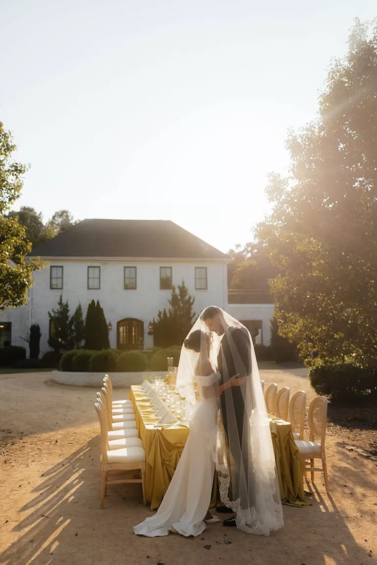 Bride and groom under veil at a golden hour reception setup at The Bradford NC.
