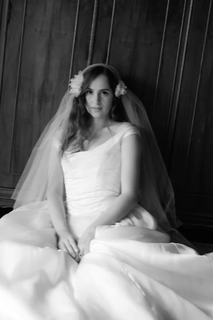 Black and white portrait of bride seated with veil and full skirt at Finca Morneta