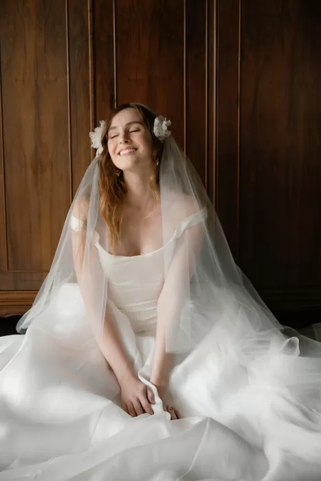 Bride sitting in front of wooden wardrobe in bridal suite at Finca Morneta
