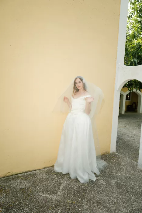 Bride portrait in veil against yellow wall and archway at Finca Morneta