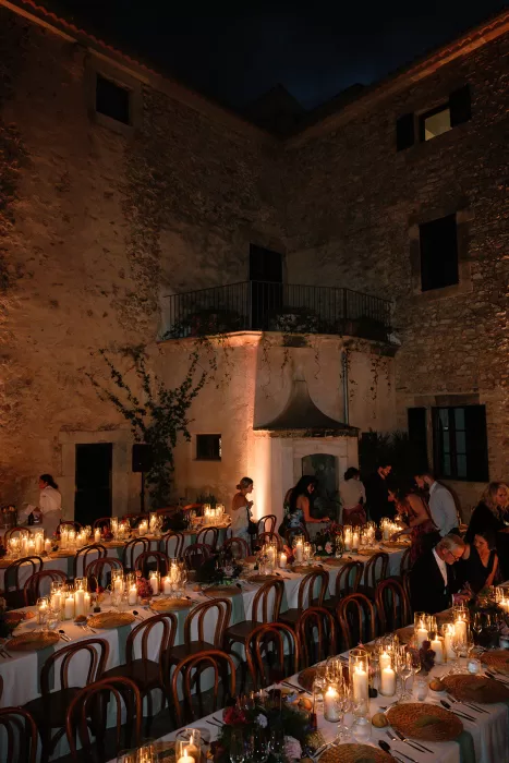 Guests dining by candlelight in courtyard reception at Finca Morneta at night