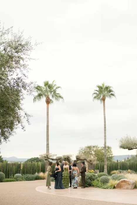 Guests gathering in landscaped garden with palm trees at Finca Morneta
