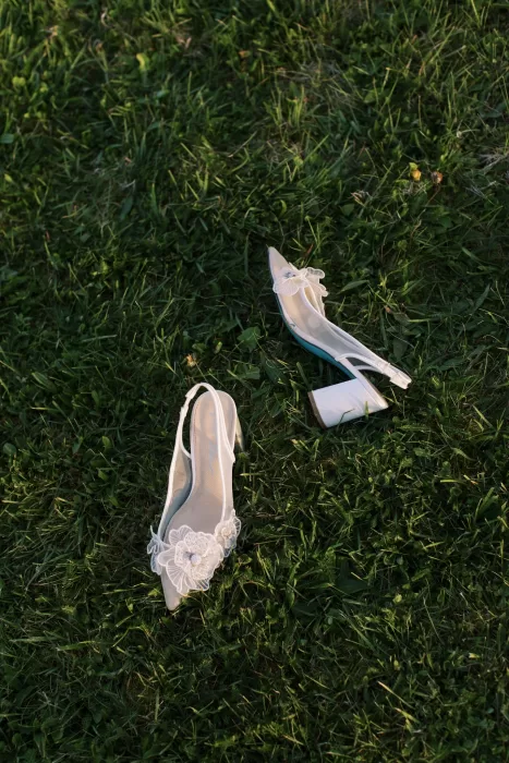 Bridal shoes with floral detail resting on grass at Fraser River Lodge