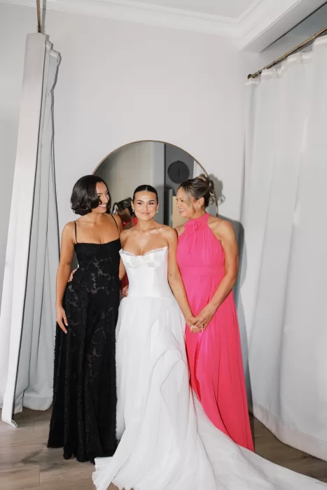 Bride smiling with friends in contrasting dresses during getting ready at Fraser River Lodge