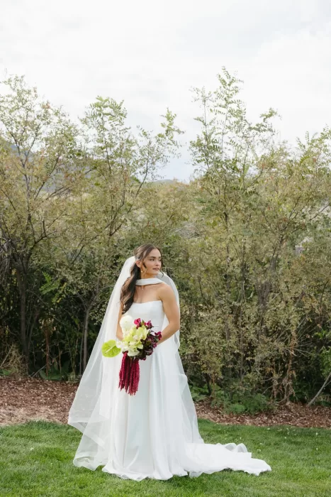 Bridal portrait on the lawn at The Manor House with a dramatic bouquet and soft veil.
