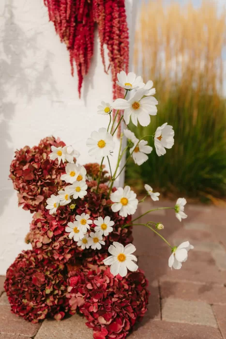 Close-up of ceremony flowers in white and deep burgundy tones at The Manor House.