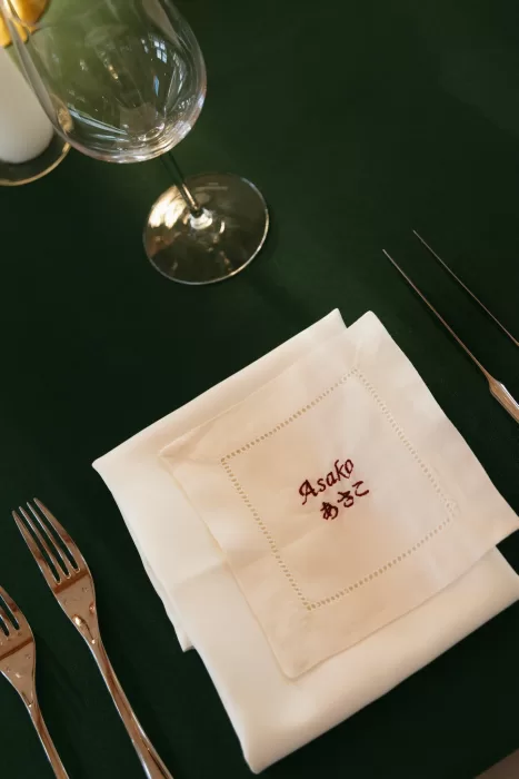 Elegant reception place setting with embroidered napkin detail at The Manor House.