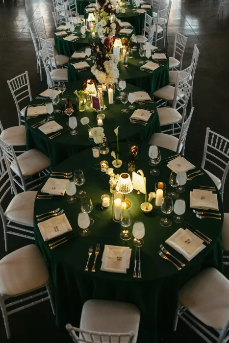 Reception tables styled with green linens, candlelight and floral centrepieces at The Manor House.