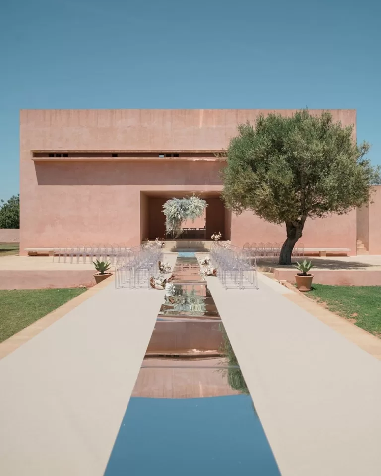 Minimalist outdoor ceremony with mirrored aisle and structured altar, captured by Puy Cermeño