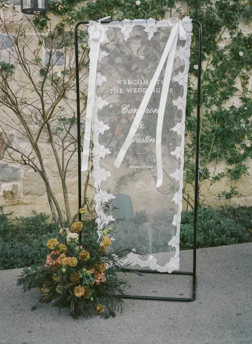 Wedding welcome sign with lace detailing displayed outdoors at Monserate Winery San Diego