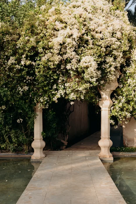 Bougainvillea-covered archway leading to shaded garden path at Palais Namaskar